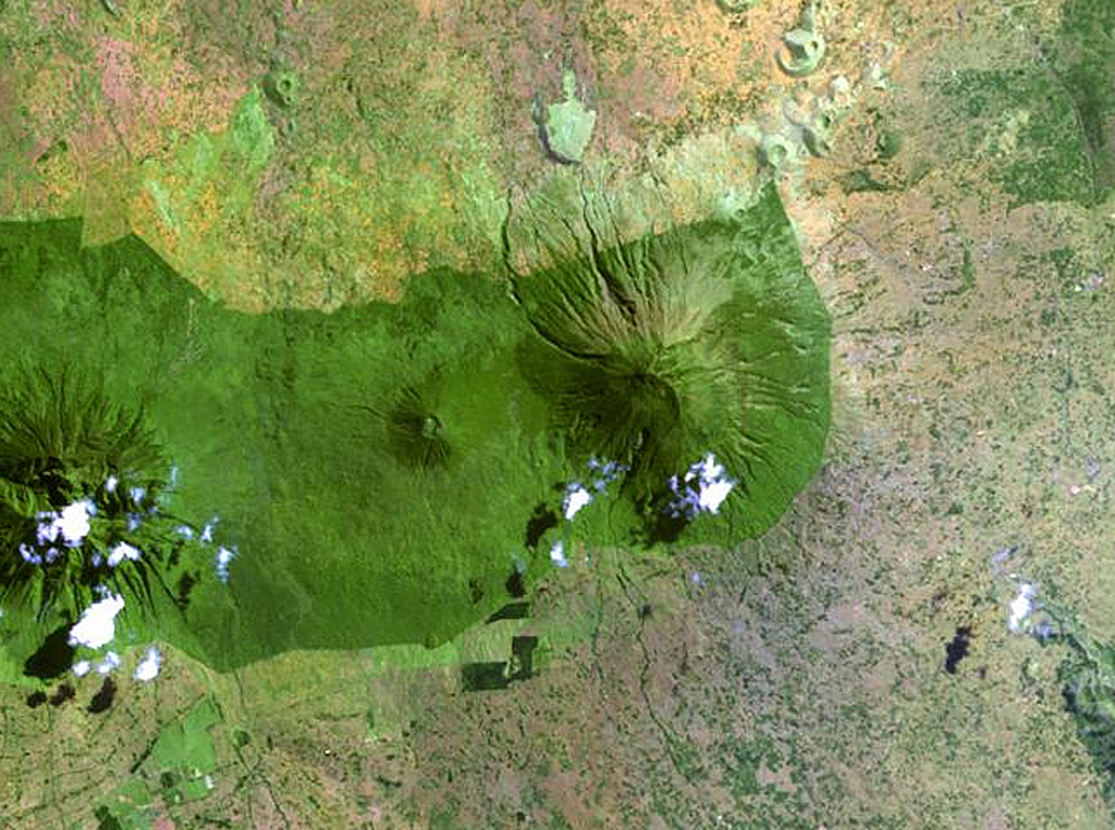 The forested Muhavura volcano (center) rises at the NE end of the Virunga Range. The Gahinga (Mgahinga) volcano, the smaller cone at left-center, is joined to Muhavura on the west by a broad saddle. Muhavura is stratovolcano with a small crater that has been recently active, but the age of its latest eruption is not known. NASA Landsat image, 1999 (courtesy of Hawaii Synergy Project, Univ. of Hawaii Institute of Geophysics & Planetology).