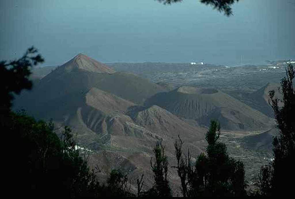 A view to the NW from Green Mountain shows The Sisters (left) and Perfect Crater (right-center), cinder cones on the flanks of the Ascensión Island volcano, which lies just west of the Mid-Atlantic Ridge. The isolated island contains numerous cones and lava domes. Many volcanic features on Ascensión have a very youthful appearance, and three eruptions have been dated within the past 2,000 years, the most recent being the South Sisters flow, possibly only 500 years old. Photo by Jon Davidson (University of Durham).