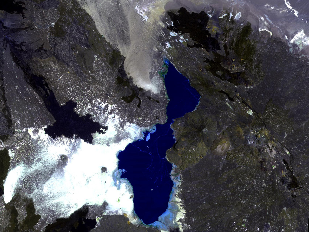 The Tat Ali volcanic massif extends across the right-hand side of this NASA Landsat image, east of Lake Afrera (center). This basaltic-to-pantelleritic shield volcano displays an elongated central depression partially filled by recent basaltic lava flows. The dark-colored flows at the upper right were erupted from fissures at the northern end of the Tat Ali complex. Borawli volcano lies at the right-center, between Tat Ali and Lake Afrera (also known as Lake Giulietti), and the lava flows at the upper left are from the flanks of the Hayli Dubbi complex. NASA Landsat image, 1999 (courtesy of Hawaii Synergy Project, Univ. of Hawaii Institute of Geophysics & Planetology).