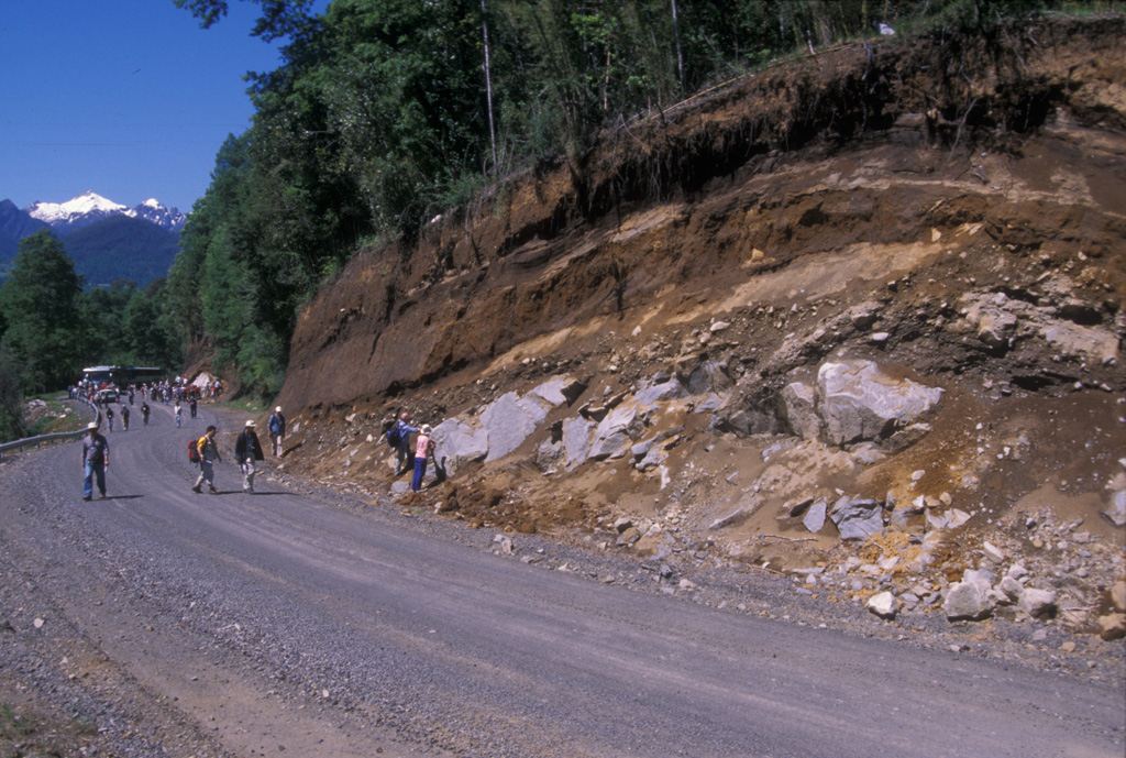 Volcanologists on a field trip during the 2004 Chile IAVCEI conference examine an outcrop of the Caburgua-Huelemolle volcano group.  Miocene granodiorites at the base of the roadcut are overlain by postglacial pyroclastic deposits from basaltic cones of the Caburgua-Huelemolle group. Photo by Jim Luhr, 2004 (Smithsonian Institution).