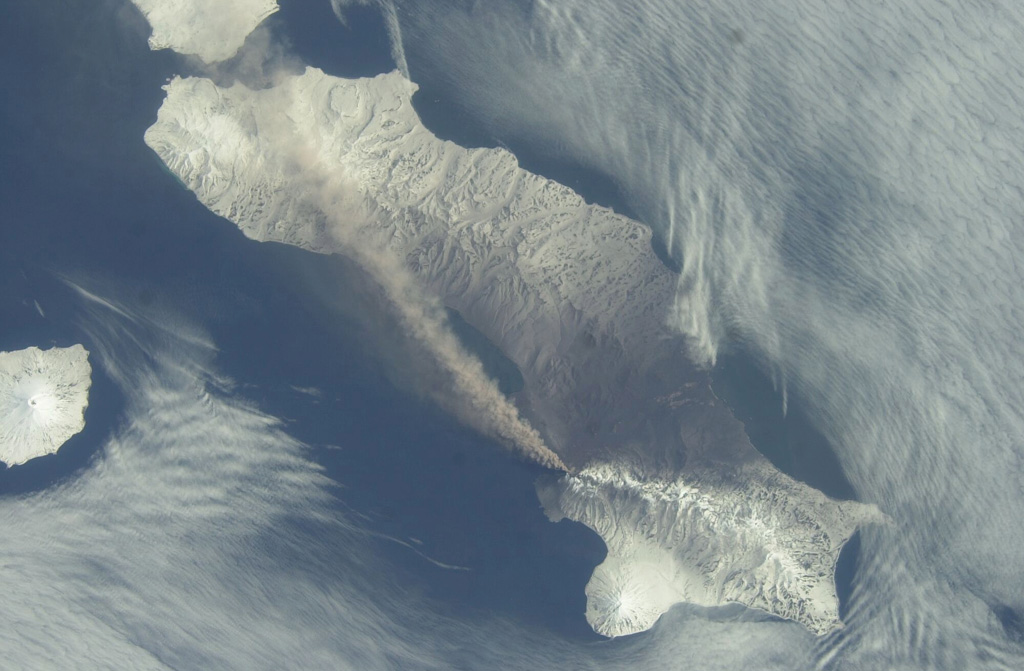 An ash plume extends across the length of Paramushir Island in the northern Kuril Islands on 26 April 2003 in this NASA Space Shuttle image (with N to the left). An explosive eruption of Chikurachki began on 18 April, producing ash plumes up to about 2 km above the crater. On 1 May ash fell on the town of Severo-Kurilsk (~60 km from the volcano), and intermittent activity continued until early July. Alaid volcano is at the far left. NASA International Space Station image ISS006-E-52695, 2003 (http://eol.jsc.nasa.gov/).