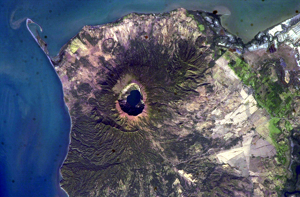 The steep-walled, lake-filled summit caldera of Cosigüina volcano is prominent in this NASA International Space Station image with north to the upper left.  Bahia el Rosario lies to the right of the elongate peninsula at the upper left with Punta San Jose at its tip, and the town of Potosi is at the top center.  The scarp of an older caldera rim forms Filete Cresta Montosa, the semi-arcuate ridge below the summit caldera.  This scarp continues in a more subdued form to the northern side of the volcano. NASA International Space Station image ISS006-E-51438, 2003 (http://eol.jsc.nasa.gov/).