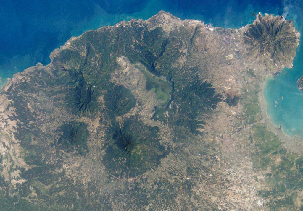 Karang is the large, circular, forested volcano below and to the left of the center of this NASA International Space Station image (N is to the upper right) is. It is located to the SE of the 15-km-wide Pleistocene Danau caldera visible above the center of the image. There are two craters on the SE flank of Karang volcano, the highest peak in this volcanic region at the western tip of Java. NASA International Space Station image ISS004-E-10353, 2002 (http://eol.jsc.nasa.gov/).