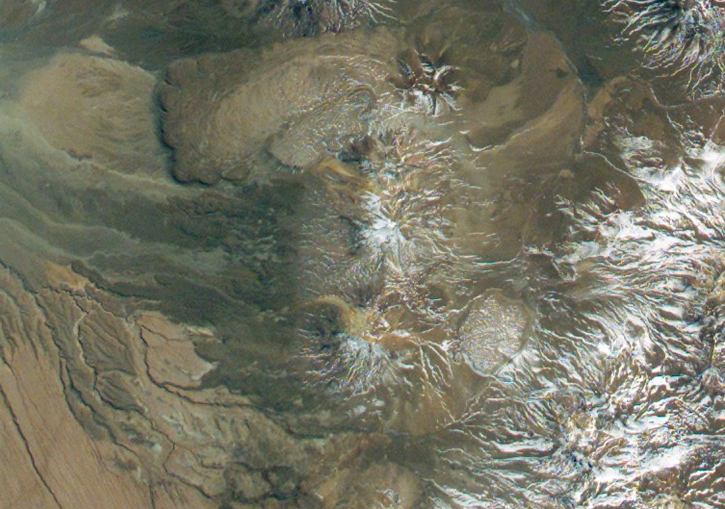 Cerro del León (center) is an andesitic stratovolcano flanked by two massive dacitic lava domes, Chillahuita to the SE (the circular dome to the lower right) and Chao to the NW.  Chao forms the massive box-shaped dome and lava flow at the top center in this NASA International Space Station image (with north to the upper left) and is the world's largest of its type.  The 14.5-km-long dacitic lava flow has distal margins that are 350-400 m high and formed in several eruptive pulses. NASA International Space Station image ISS005-E-8788, 2002 (http://eol.jsc.nasa.gov/).
