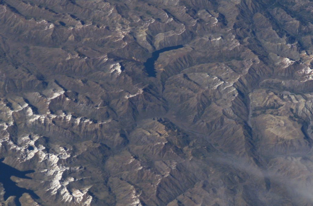 The crescent-shaped lake at the top-center of this NASA International Space Station image (with north to the bottom right) is Laguna del Dial.  A cinder cone named Volcán Resago, on the SE side of the lake, produced a basaltic-andesite lava flow that traveled about 3 km to the WNW into Laguna Dial.  The youthful cone may have been formed during an undocumented eruption during historical time.  The lake at the lower left is Laguna Valvarco. NASA International Space Station image ISS008-E-7432, 2003 (http://eol.jsc.nasa.gov/).