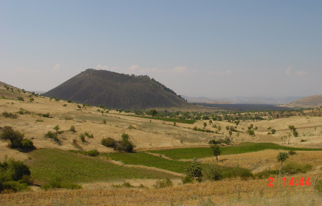 The Kara Divlit Tepe ("Black Ink Cone") scoria cone is part of the Kula volcanic field, the westernmost area of young volcanism in Turkey. It is the youngest of the broad Quaternary volcanic field, which is mostly Pleistocene in age. The 300-m-high cone produced a voluminous lava flow (visible to the N, right of the cone) that traveled 22 km NW and is one of the two youngest flows at Kula. The Kula volcanic field contains a group of cones and maars erupted along a roughly E-W-trending line. Photo by Samuele Agostini, 2000 (CNR, Pisa, Italy).