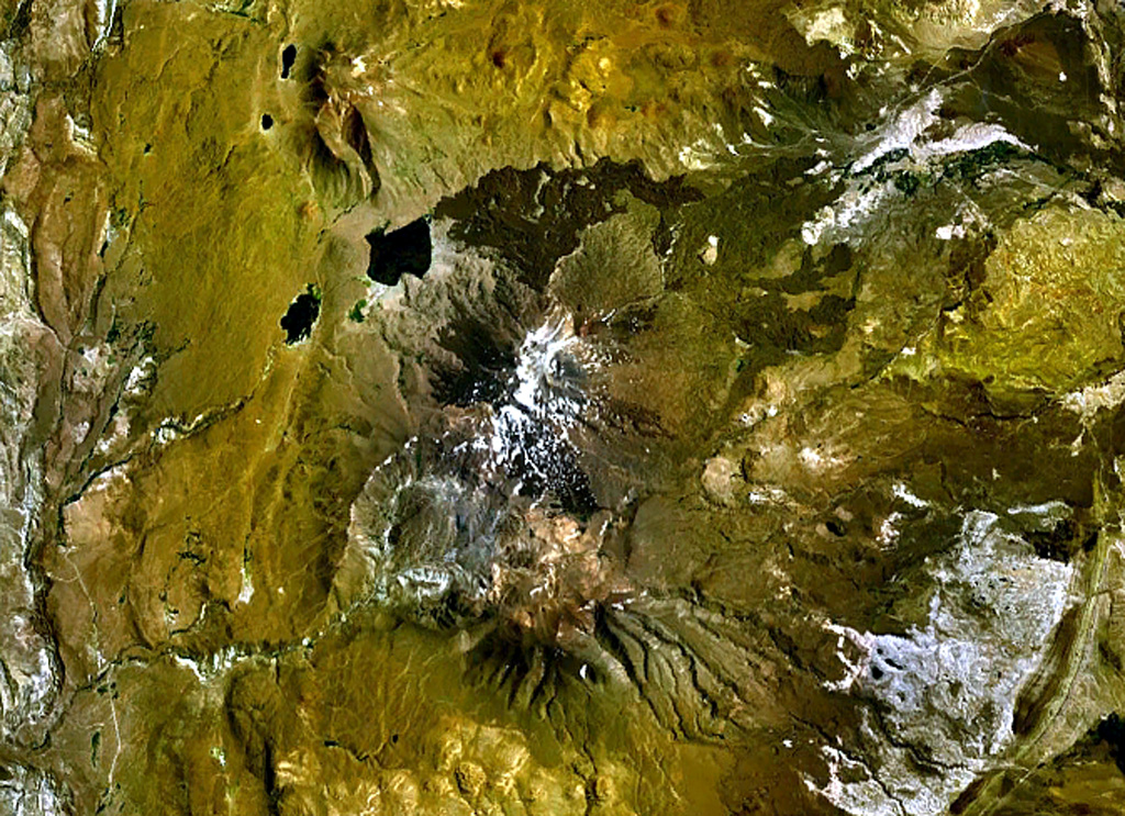 Tromen (center) is a 3978-m-high youthful Argentinian stratovolcano that lies at the northern end of an elongated volcanic massif.  The summit of Tromen is cut by two overlapping 3.5-km-wide calderas, visible south of the snow-dappled summit cone in this NASA Landsat view (with north to the top).  The youngest lava flows at Tromen originated from north-flanks vents and produced the dark-colored lava flows that blanket the north and NE sides of the andesitic-to-dacitic volcano.   NASA Landsat 7 image (worldwind.arc.nasa.gov)