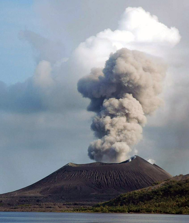 An ash plume rises above Tavurvur volcano at the eastern end of the island of New Britain in Papua New Guinea on 5 June 2005, seen from the SE. Explosive activity had resumed at Tavurvur on 25 January 2005 and continued intermittently until November of that year, occasionally depositing ash on the town of Rabaul. Incandescent ejecta was periodically observed at night time. Photo by Roy Price, 2005 (University of South Florida).