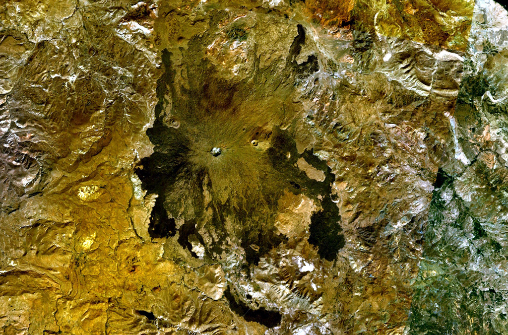 Two circular craters lie along an E-W trend on the summit ridge of Tendürek Dagi shield volcano in this NASA Landsat composite image (with north to the top). The higher western cone is capped by a steep-walled crater, and the flatter eastern crater contains a lake. Late-stage activity formed trachytic lava domes and flows as well as basaltic pahoehoe flows that extend 10-20 km N and S. NASA Landsat 7 image (worldwind.arc.nasa.gov)
