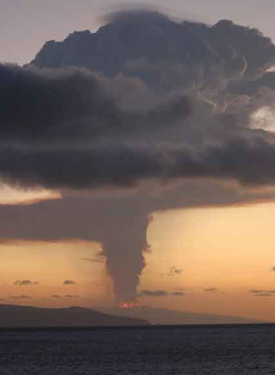 Incandescent lava fountains and eruption column from Sierra Negra are seen from Cerro Dragon on Santa Cruz Island sometime after the onset of the eruption at about 1700 hrs on October 22, 2005.  Satellite imagery indicated that the eruption plume reached at least 15 km altitude.  The lava fountains were estimated to be about 200-300 m high. Photo by Lucho Verdesoto, 2005.