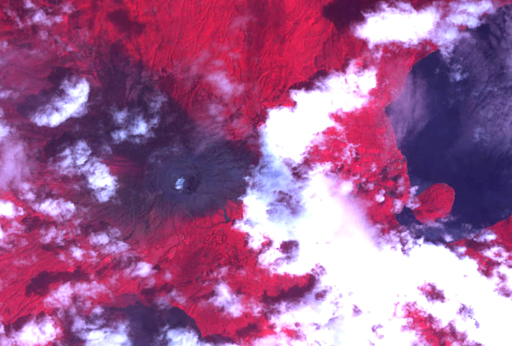 The summit crater complex of Santa Ana volcano with its small crater lake is visible left of center in this NASA ASTER image (with north to the top) taken on October 10, 2005, following an explosive eruption on October 1.  In this false-color image dark ashfall deposits cover otherwise reddish vegetation around the summit of the volcano and extend down its upper eastern flank.  The eruption occurred just prior to heavy rainfall accompanying Hurricane Stan, and lahars swept the flanks of the volcano.  The large lake at the right is Coatepeque caldera.   NASA ASTER image, 2005 (https://earthobservatory.nasa.gov/).