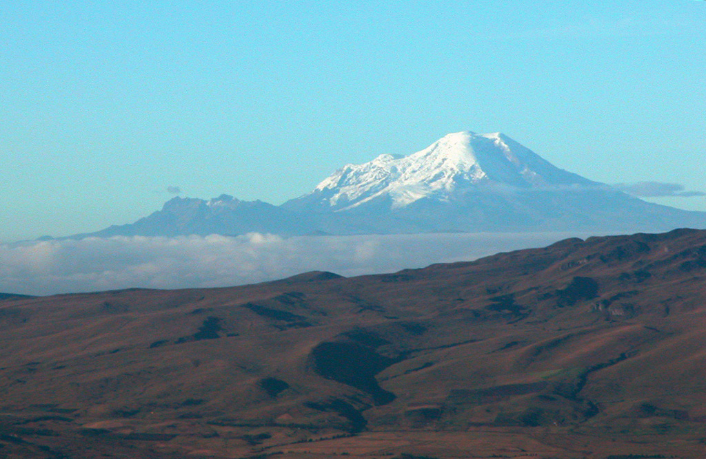 Glacier-clad, 6310-m-high Chimborazo is Ecuador's highest volcano.  It is seen here from the NE with Carihuairazo volcano forming the lower, mostly snow-free peak to the left.  The youngest and westernmost of three edifices constructed along an E-W line forms the current summit of Chimborazo.  Although activity was once thought to have ceased during the very latest Pleistocene, recent work indicates that Chimborazo erupted several times during the Holocene. Photo by Patricio Ramon, 2004 (Instituto Geofisca, Escuela Politecnica Nacional).