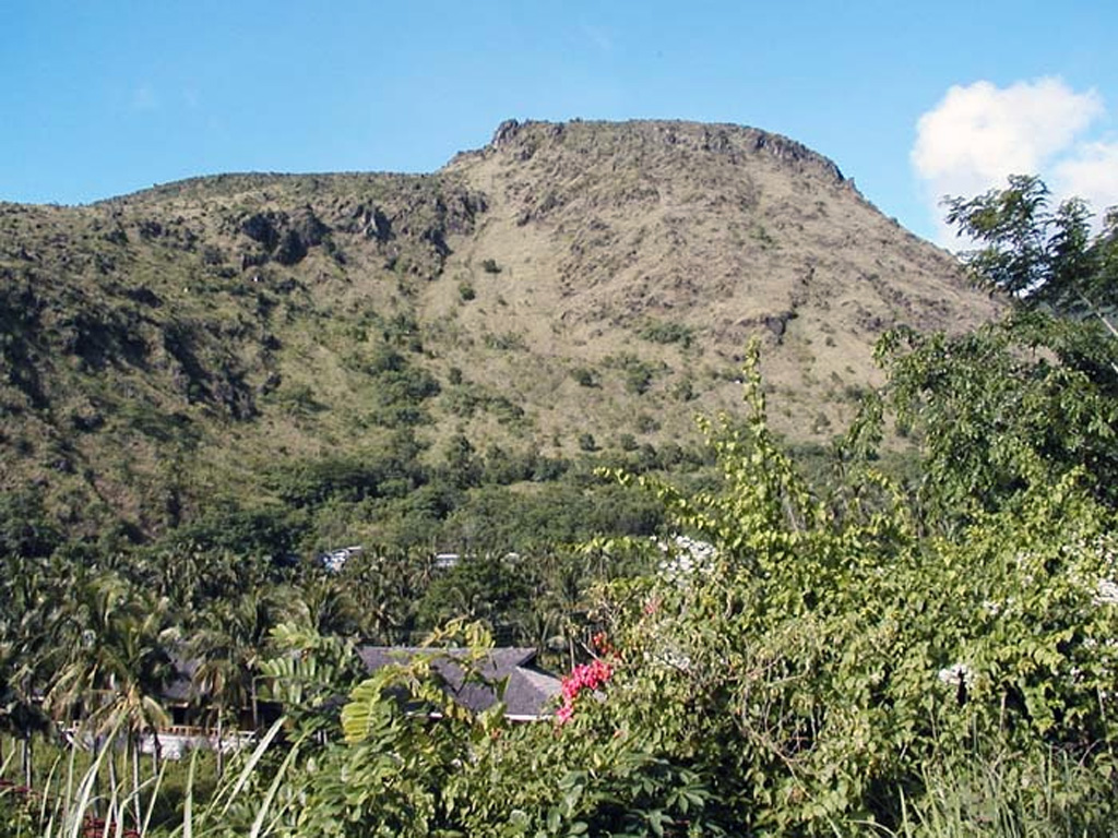 Mt. Vulcan, a lava dome on the NW flank of the Hibok-Hibok lava-dome complex, formed during the 1871-1875 eruption. Following earthquakes beginning in January 1871, an explosion occurred on 30 April from a vent on the NW flank near the coast, destroying an area with a 3 km radius. Explosive activity continued for about a week, after which lava effusion began. Dome growth lasted for four years, producing by 1875 a dome about 1.6 km in diameter.  Photo by Juny La Putt, 2002.