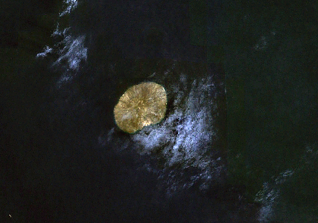 The small, oval-shaped island in this NASA Landsat image (with north to the top) is Jebel at Tair. This 3-km-wide island is the emergent summit of a stratovolcano that rises from a 1,200 m depth in the south-central Red Sea. Youthful lava flows from a steep-sided central vent, Jebel Duchan, cover most of the island. The island is of Holocene age, and explosive eruptions were reported in the 18th and 19th centuries. NASA Landsat 7 image (worldwind.arc.nasa.gov)