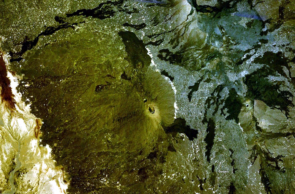The prominent peak near the center of this NASA Landsat image (with north to the top) is Ale Bagu, also known as Ummuna. This elongated stratovolcano is the highest of the Erta Ale Range volcanoes. The main crater is the 750 x 450 m feature prominent in this image. The light-colored Roram Plain lies at the lower left, and lava flows from Hayli Gubbi volcano are visible at the right. NASA Landsat 7 image (worldwind.arc.nasa.gov)