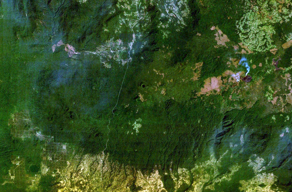 The densely forested Tepi basaltic shield volcano lies about 300 km west of the Ethiopian Rift in southern Ethiopia. A small crater near the center of this NASA Landsat image (with north to the top) is one of many features on this broad volcano. Lava flows have traveled down pre-existing valleys, and there are active hot springs. The smoke plume at the right is from a vegetation fire. NASA Landsat 7 image (worldwind.arc.nasa.gov)