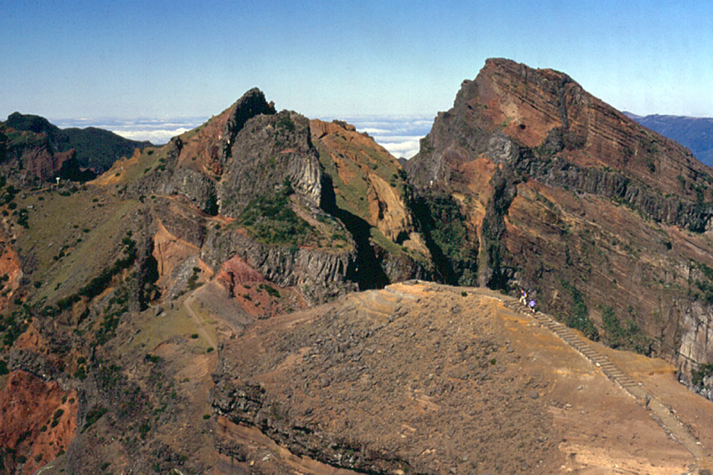 The rugged summit of Pico Ruvio forms the high point of the island of Madeira. This eroded scoria cone complex was erupted during Pliocene-to-Pleistocene rift activity along the axis of the Madeira rift. Dense swarms of dikes, some of which are visible in this image (dark gray bands), are oriented E-W, parallel to the orientation of the rift. Photo by Paul Bernhardt.