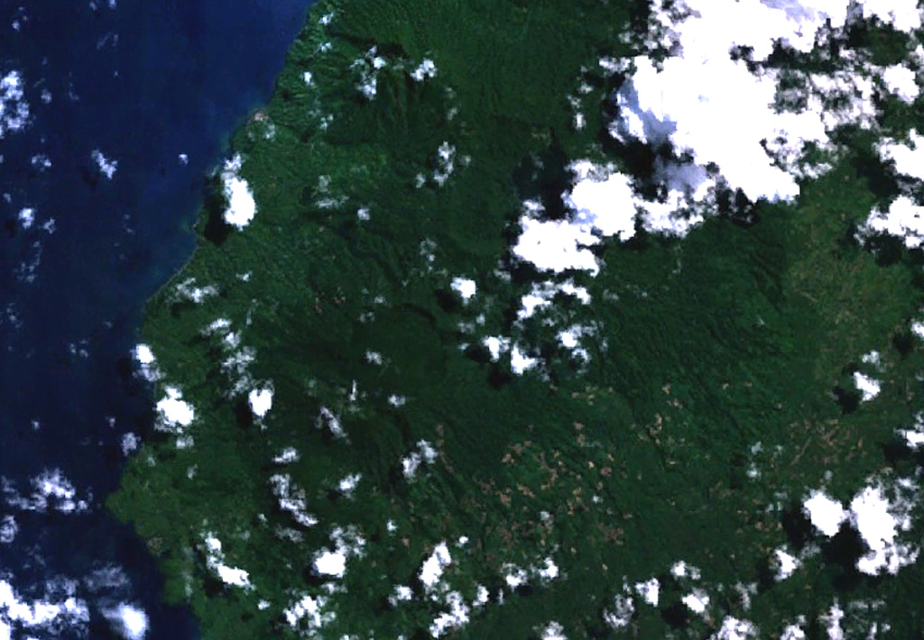 The twin caldera complex of Todoko-Ranu appears in this NASA Landsat image of western Halmahera Island (with north to the top).  Todoko caldera (the circular feature just left of center) lies SW of nested calderas at Ranu, the northern of which contains a lake, faintly visible above the clouds above and to the right of the center of the image.  No historical eruptions have been reported from the complex, but fumaroles and hot springs are present, and youthful-looking lava flows have reached the sea. NASA Landsat 7 image (worldwind.arc.nasa.gov)