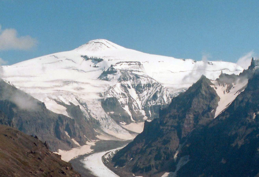 Glacial valleys descend from the western side of Alney, which along with Chashakondzha, forms one of the largest volcanic complexes of the Sredinny Range. This is one of the few large stratovolcanoes in the Sredinny Range known to have been active throughout the Holocene, with more than 30 documented pyroclastic deposits. Scoria cones on the eastern flanks formed during the Holocene. Copyrighted photo by Adam Kirilenko, 2003.