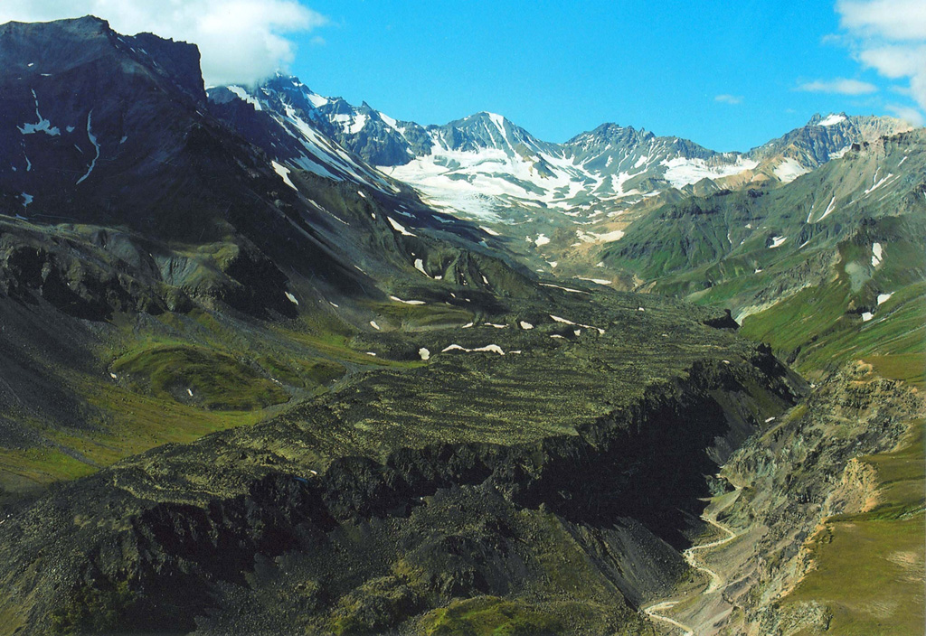 The Levaya Belaya lava flow erupted from a cone 5 km ENE of the summit of Chashakondzha. Compressional ridges are visible in the middle of the photo, and the Levaya Belaya River has cut a channel along the northern flow margin. The lava was radiocarbon dated to about 2,610 years ago. Copyrighted photo by Adam Kirilenko, 2002.