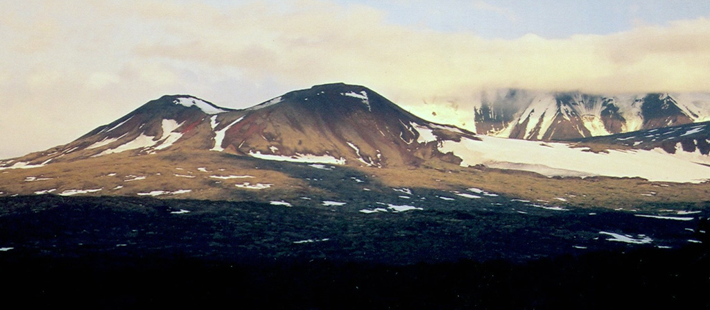 This cone formed at the top of Nylgimelkin, with the larger Pleistocene Khuvkhoitun volcano visible in the background. Lava flows from Nylgimelkin were erupted along a fissure about 5,500 years ago. Copyrighted photo by Maria Pevzner, 2005 (Russian Academy of Sciences, Moscow).