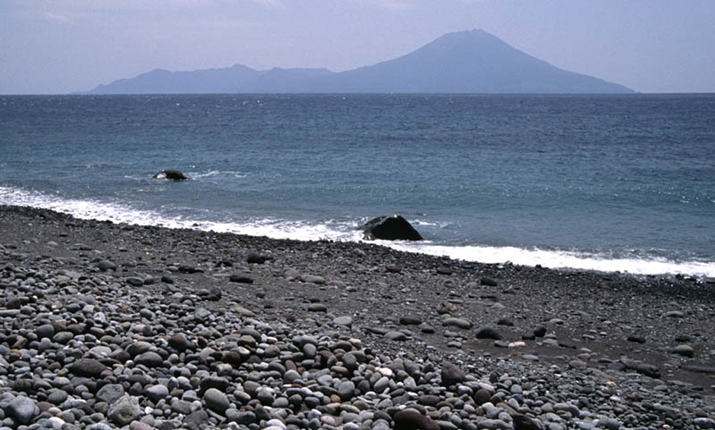 Nakanoshima island is seen here from a beach on Kuchinoshima to the NNE. The active cone of Ontake to the right has a summit crater that fills with water during the rainy season. The 9 x 5 km island is surrounded by coral reefs, and a flat plateau separates it from an older dissected volcano to the south. Minor activity has been reported in historical time. Copyrighted photo by Shun Nakano, 2005 (Japanese Quaternary Volcanoes database, RIODB, http://riodb02.ibase.aist.go.jp/strata/VOL_JP/EN/index.htm and Geol Surv Japan, AIST, http://www.gsj.jp/).