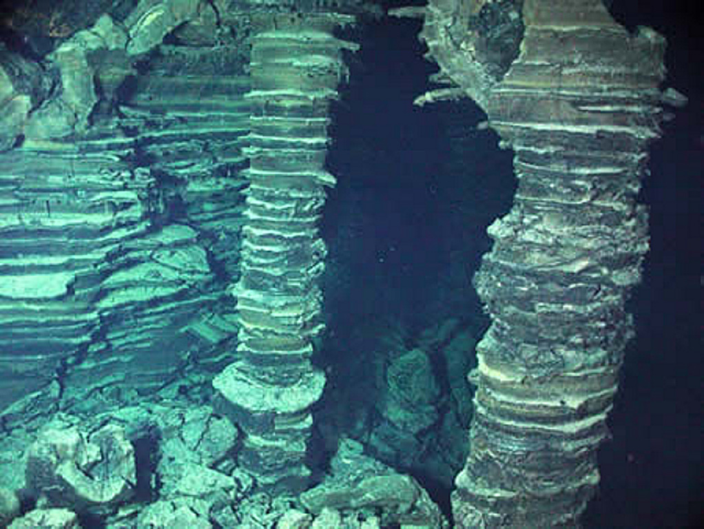 Lava pillars supporting the upper crust remain after collapse of a lava flow that erupted from Axial volcano in 1998. The layers within the lava formed when ponded lava drained away. A seismic swarm was detected at Axial Seamount beginning on 25 January 1998. An oceanographic cruise during 9-16 February detected elevated hydrothermal plumes, and later mapping indicated that a submarine lava flow had extruded from a 9-km-long fissure system. Photo courtesy of NOAA NeMo Observatory, 2006.