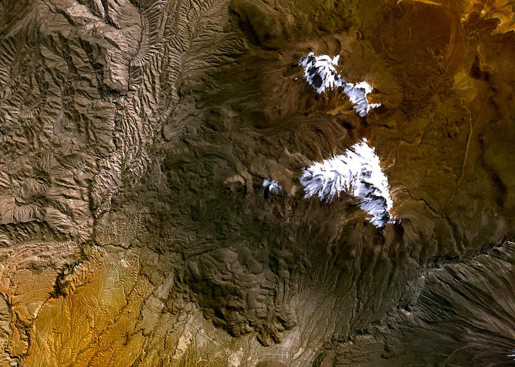 The glacier-capped Nevado de Chachani volcanic complex lies immediately north of the city of Arequipa.  The central part of the 6057-m-high complex contains multiple vents along an arcuate line.  Pleistocene lava domes form the glacier-covered northern end of the complex in this NASA image.  A prominent lava-flow complex at the bottom-center part of the image with fresh-looking flow levees was erupted from the 8-km-wide lava shield of Pampa de Palacio of late-Pleistocene to possibly Holocene age. NASA Landsat 7 image (worldwind.arc.nasa.gov)