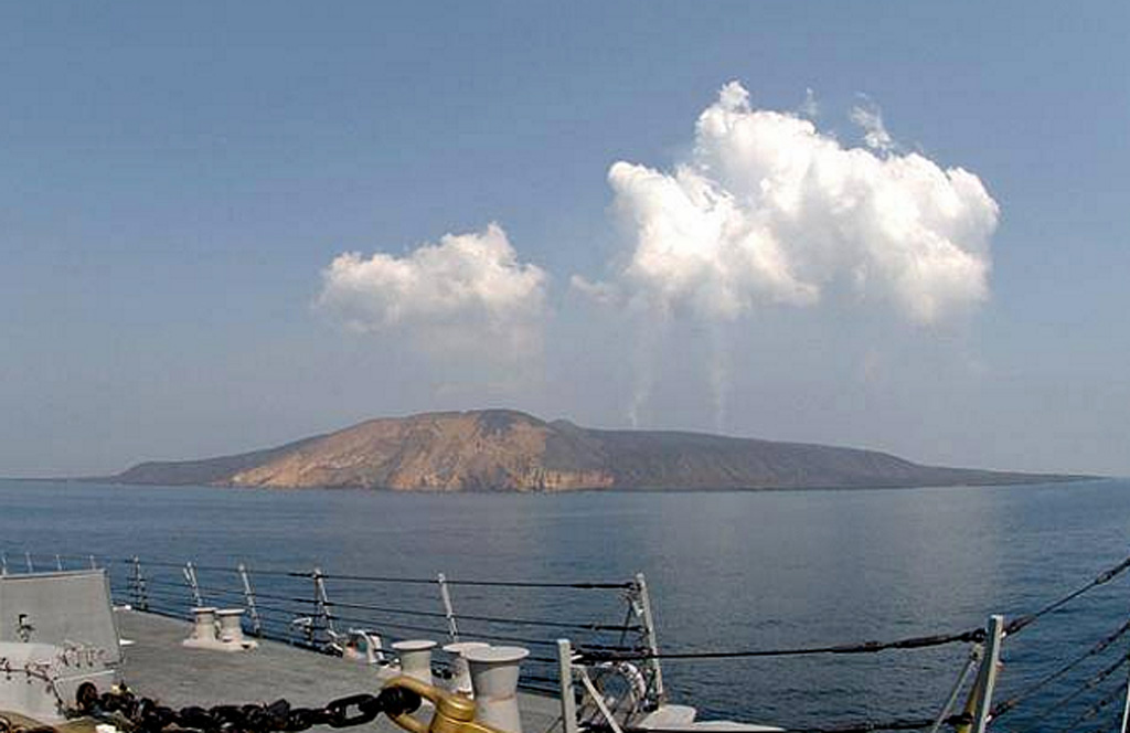Plumes are visible from the eruption of Jebel at Tair rise above the volcano as seen from the U.S. Navy vessel USS Bainbridge on 2 October 2007, two days after the start of the eruption. The small, 3-km-wide island rises from a 1,200 m depth in the south-central Red Sea. Jebel at Tair (one of many variations of the name, including Djebel Teyr, Jabal at Tayr, and Jibbel Tir) is the northernmost known Holocene volcano in the Red Sea. Historical eruptions date back to the 18th century. Photo by Vincent J. Street, 2007 (U.S. Navy).