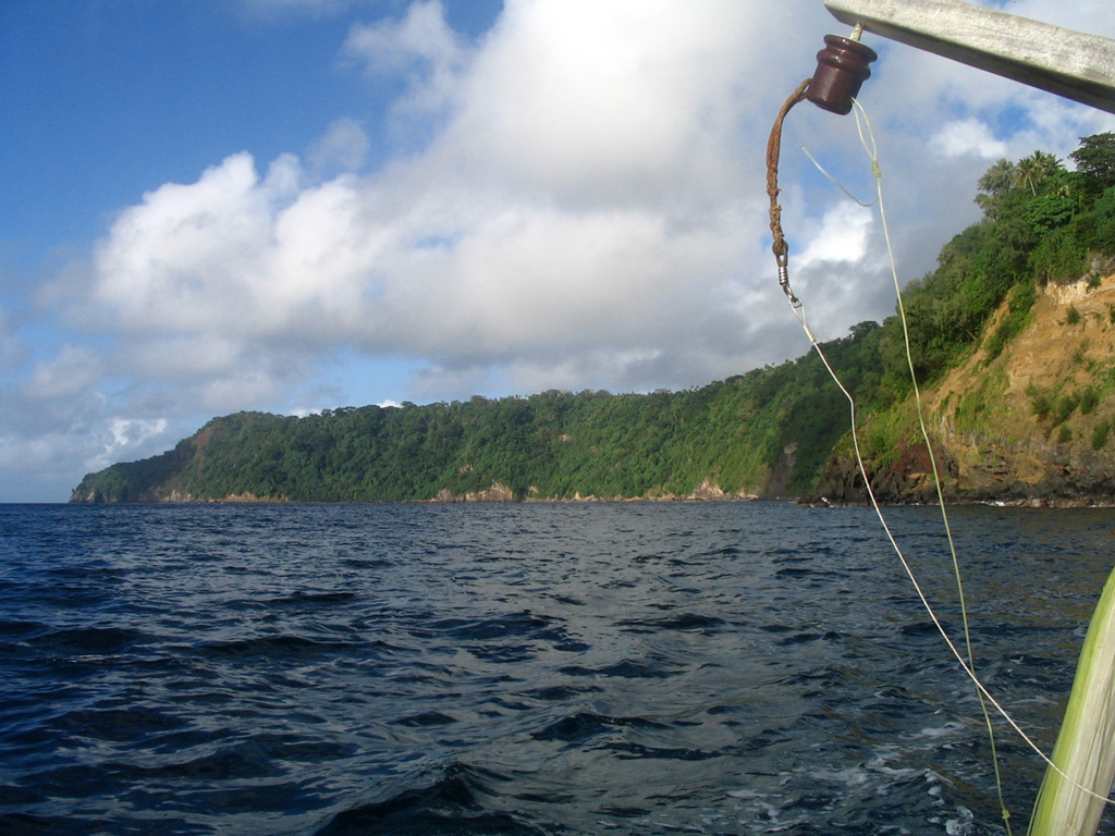 The forested cliff marks the upper caldera wall of the largely-submarine Kuwae caldera between Epi and Tongoa islands. The 6 x 12 km caldera contains two basins that cut the NW end of Tongoa Island and the flank of the late-Pleistocene or Holocene Tavani Ruru volcano on the SE tip of Epi Island. The Karua volcano lies near the northern rim of the caldera. It has formed several ephemeral islands since it was first observed in eruption during 1897. Photo by Karoly Nemeth, 2005 (Massey University).