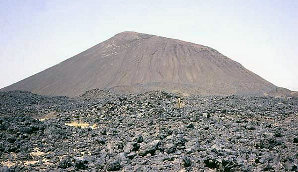 This small Aïr basaltic scoria cone and lava flow are part of the Todra volcanic field, which covers a broad area of about 1,050 km2 in the Tuareg shield in the southern Aïr region of Niger. Construction of about 30 volcanoes was followed by the formation of about 130 basaltic cones. The date of the latest eruption of the Todra volcanic field is not known, but may have been as recent as a few centuries ago. Photo by Jean-Paul Liégeois (Africa Museum, Belgium).