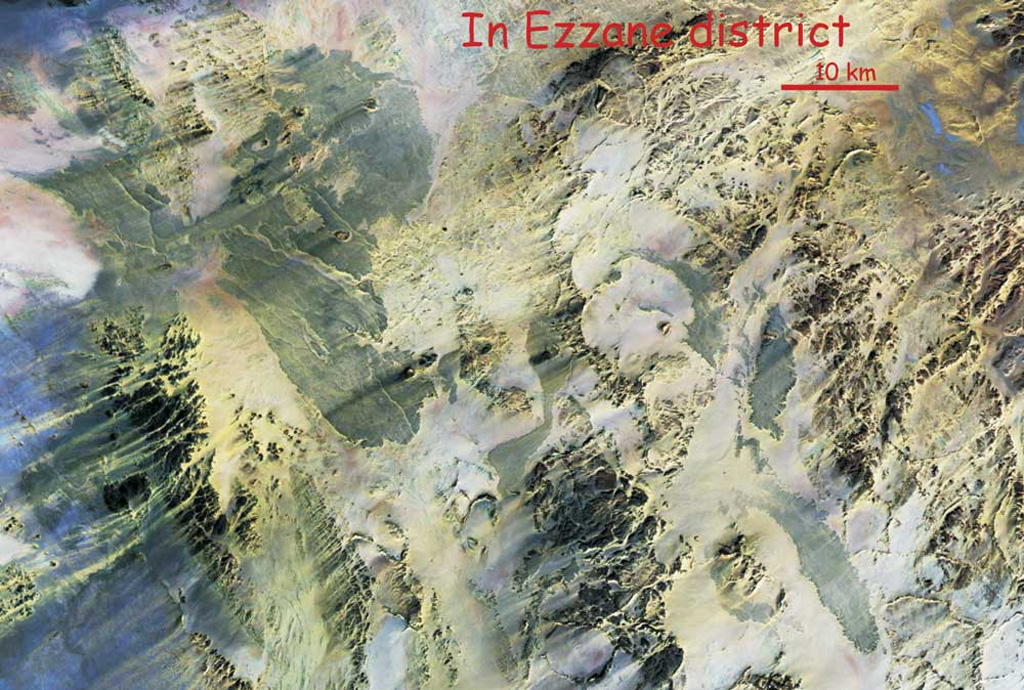 This NASA Landsat Thematic Mapper mosaic shows the In Ezzane volcanic field along the border region of Algeria and Niger. The In Ezzane volcanic field, with lava fields appearing blue-gray in this image, covers about 500 km2 at the eastern end of Hoggar (Ahaggar) volcanic province. This poorly known and isolated volcanic field erupted through basement rocks at the western end of the Saharan meta-craton. NASA Landsat Thematic Mapper mosaic by Jean-Paul Liégeois (Africa Museum, Belgium).