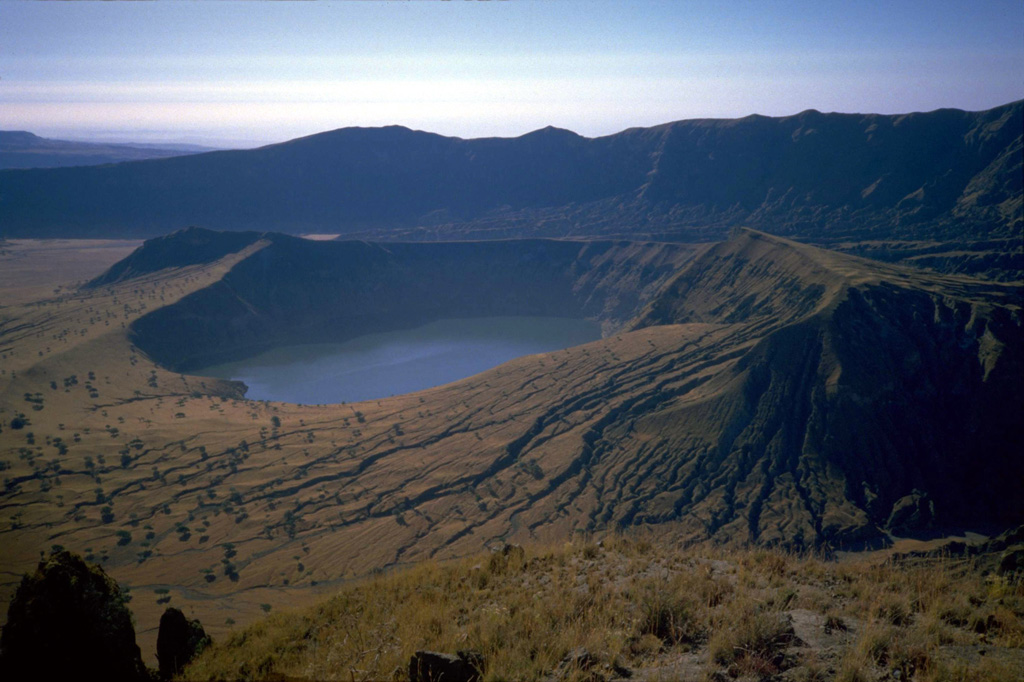 A lake partially fills a younger cone within the Deriba caldera of Jebel Marra volcano in this view from the N. The 5-km-wide, steep-walled caldera, whose wall appears in the background, was formed about 3,500 years ago at the time of the eruption of voluminous airfall pumice and pyroclastic flows that traveled more than 30 km from the volcano. Post-caldera ash eruptions may have continued into historical time. Photo by J. Williams, 1986 (http://en.wikipedia.org/wiki/Image:Sudan_Jebel_Marra_Deriba_Lakes.jpg)