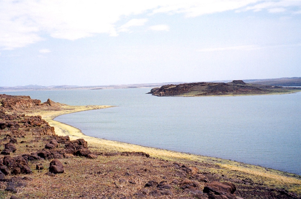 South Island (right) is the southernmost and largest of the three volcanic islands in Lake Turkana. The island (sometimes referred to as Hohnel Island) contains numerous cones and rises 320 m above the lake surface. Lava flows erupted from a N-S fissure extending the 11-km length of the island. An eruption from a scoria cone on South Island was witnessed during Count von Teliki's 1888 expedition. Photo by Doron, 1999 (http://commons.wikimedia.org/wiki/Image:LakeTurkanaSouthIsland.jpg).