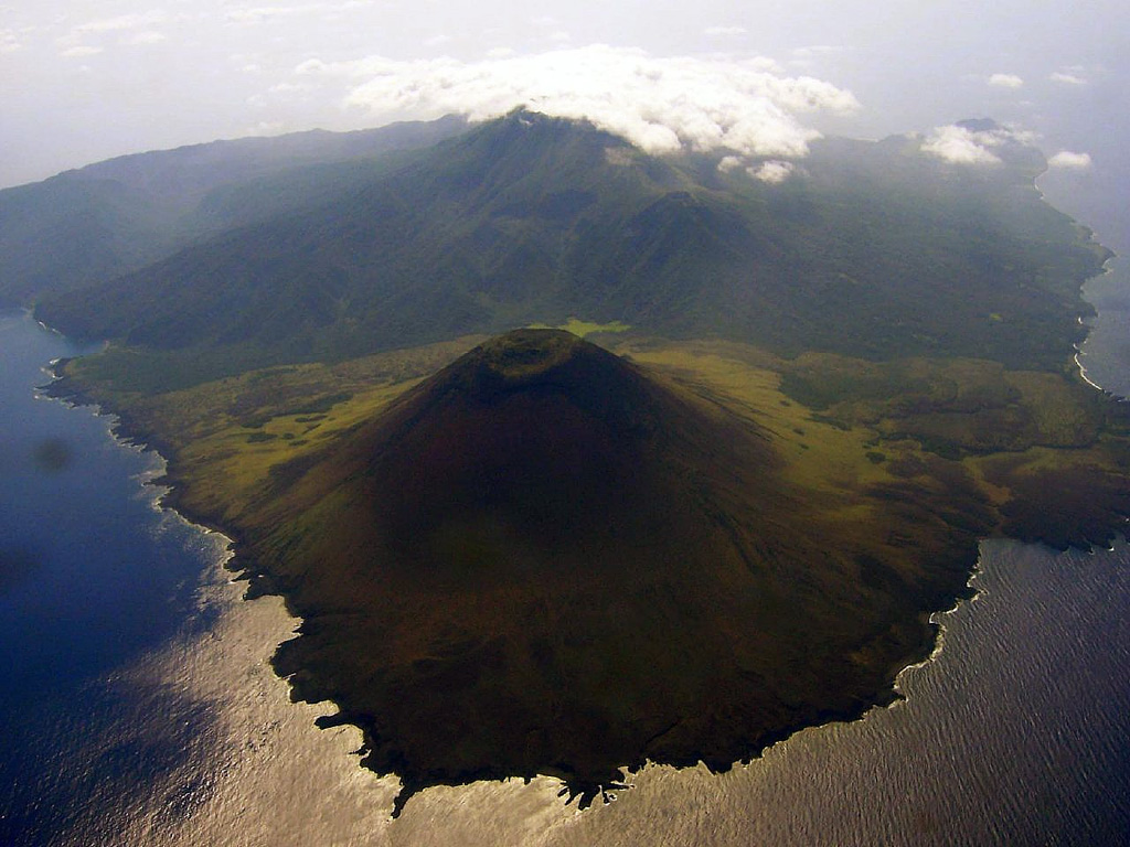 Babuyan (also called Smith volcano) in the foreground is one of five Pleistocene-to-Holocene volcanic centers occupying Babuyan de Claro Island N of Luzon. The symmetrical scoria cone is the youngest volcano on the island. Both the higher Babuyan Claro (Mt. Pangasun) and Babuyan have apparently been active in historical time, although the identity of the erupting volcano is not always certain. Photo by Bing Ramos, 2006 (http://en.wikipedia.org/wiki/Image:Didicas_Volcano_1.jpg).