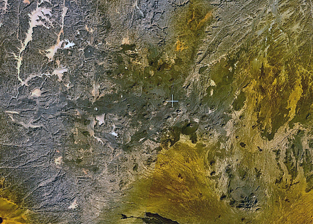Small scoria cones and lava flows of the Tarso Tôh volcanic field can be seen in the large darker-brown area at the center of this NASA Landsat image. This Pleistocene-to-Holocene volcanic field in the Tibesti Range of Chad covers a 30 x 80 km area and contains 150 scoria cones and two maars. Basaltic lava flows at Tarso Tôh were erupted over a basement of Precambrian schists and Paleozoic sandstones. The black lava flows at the very bottom-center are distal lava flows from Tarso Toussidé volcano. NASA Landsat 7 image (worldwind.arc.nasa.gov)