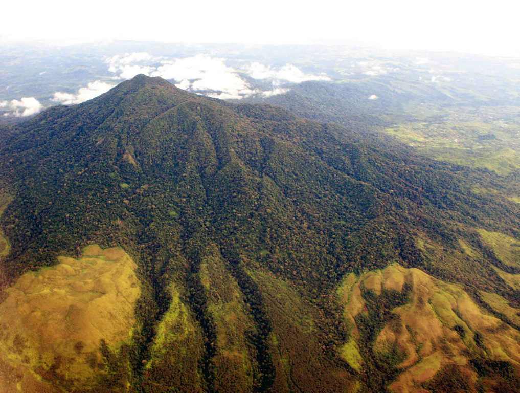 Seulawah Agam is seen here with the northern coast of Sumatra in the background. This extensively forested volcano of Pleistocene-Holocene age is located in the province of Aceh at the NW tip of Sumatra. It was constructed within the large Pleistocene Lam Teuba caldera and a smaller nested 8 x 6 km caldera. The summit contains a forested 400-m-wide crater. Copyrighted photo by Michael Thirnbeck, 2007.