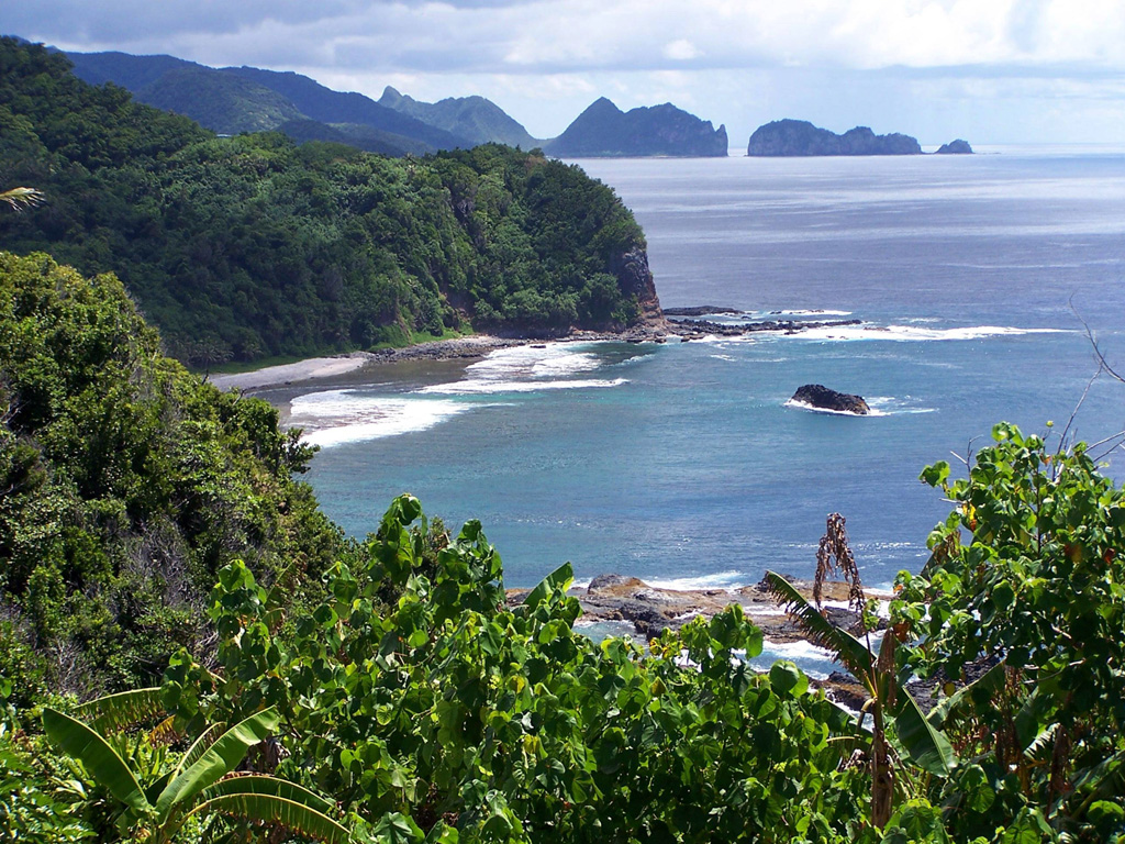 Cliffs and an offshore island mark the rugged coastline of Tutuila Island. The elongated, extensively eroded Tutuila in the center of the Samoan Islands consists of five Pliocene-to-Pleistocene volcanoes constructed along rifts trending SSW-NNE. Following a lengthy period of erosion, submergence, and the construction of a barrier reef, the Leone volcanics were erupted during the Holocene along a 5-km-long N-S-trending fissure, forming a group of scoria cones that produced pahoehoe lava flows. Photo by Tavita Togia, 2004 (U. S. National Park Service).