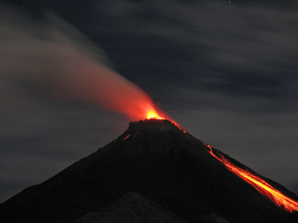 A night time view on August 28, 2007 shows incandescent ejecta from the summit crater and glowing rock avalanches down the flanks.  Activity at the frequently active Karangetang volcano had resumed with a small eruption on July 3, 2006 that produced an ash plume.  On July 12 lava flows were observed descending to the east, and a pyroclastic flow occurred on July 21.  Lava flows were also reported in August, and intermittent explosive activity continued in 2007.    Photo by Iyan Mulyana, 2007 (Centre of Volcanology & Geological Hazard Mitigation, Volcanological Survey of Indonesia).