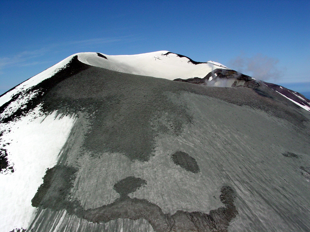 A satellite image on 4 July 2004 showed fresh ash deposits on the upper E flank of Korovin. This photo, taken from the SE, show ash emplaced on the upper slopes of the SE crater. Photo by Game McGimsey, 2004 (Alaska Volcano Observatory, U.S. Geological Survey).