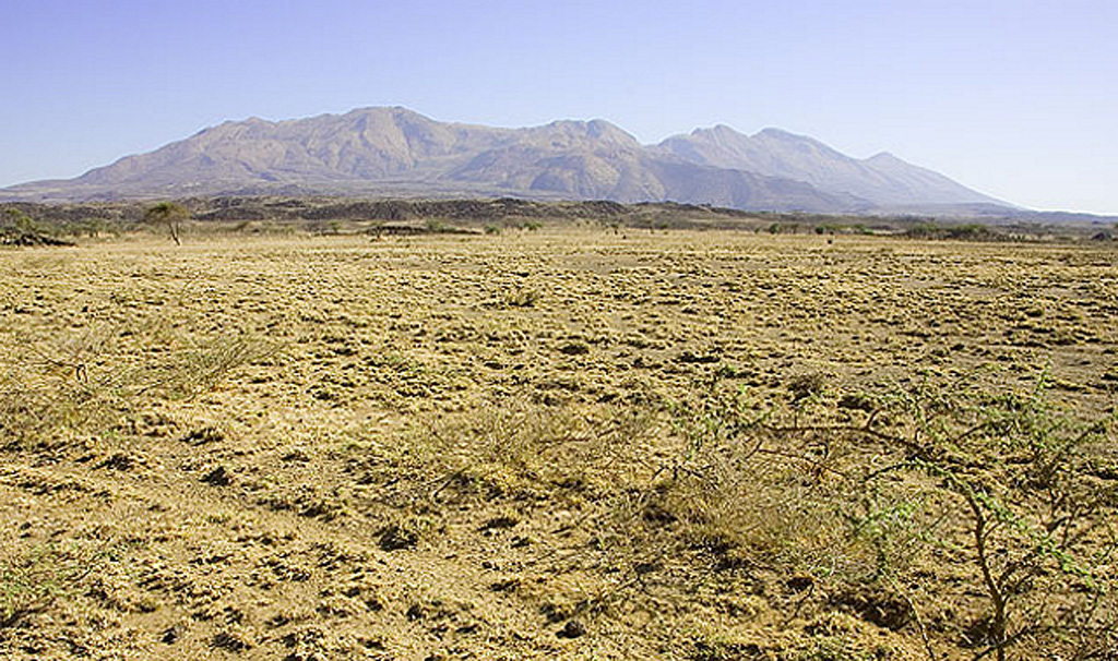 Fentale, also known as Fantale, is the stratovolcano seen here from the Ethiopian Rift. Fentale lies at the N end of the main Ethiopian Rift and consists primarily of rhyolitic obsidian lava flows with minor tuffs. Welded pyroclastic flow deposits were emplaced when the 2.5 x 4.5 km summit caldera formed. The WNW-ESE-trending elliptical caldera has an orientation perpendicular to the Ethiopian Rift, and post-caldera vents occur along the same orientation. Photo by Tom Pfeiffer, 2008 (www.volcanodiscovery.com).
