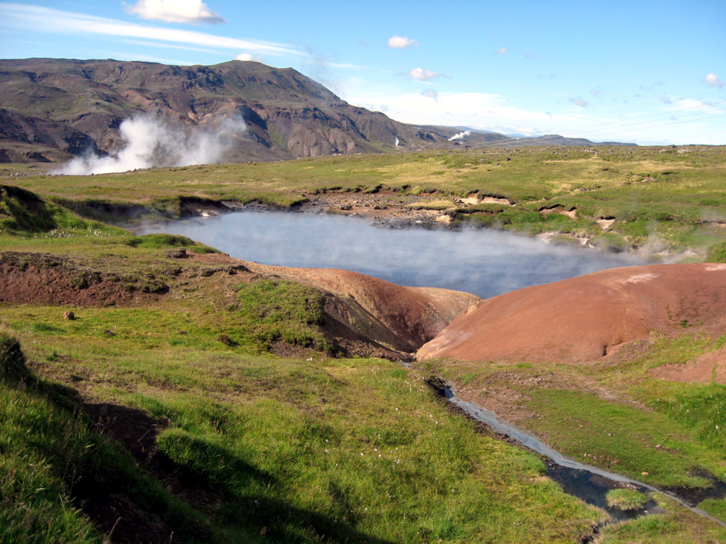 Steam rises from a hot pool in the Olkeduháls geothermal area of the Hrómundartindur volcanic system, which lies south of Thingvallavatn lake. The geothermal field contains numerous hot springs, mud pools and fumaroles. Steam plumes are visible at three locations in the background. The Hengill volcanic system forms the ridge on the skyline immediately west of the Hrómundartindur system. Photo by Lee Siebert, 2008 (Smithsonian Institution).