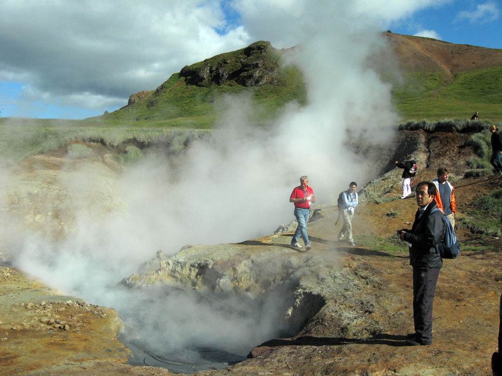 A group of volcanologists on a field trip observe activity at the Olkeduháls geothermal field of the Hrómundartindur volcanic system. The latest eruption at Hrómundartindur occurred about 11,000 years ago, from a vent about 1 km N of this geothermal field. The eruption produced a small lava flow, which reached about 4-5 km from the vent and covered about 4 km2. Photo by Lee Siebert, 2008 (Smithsonian Institution).