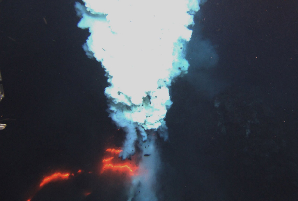 Incandescence and a plume at the Hades vent of West Mata in May 2009, a submarine volcano with a summit more than 1,000 m below the ocean surface. The volcano is located in the northeastern Lau Basin at the northern end of the Tonga arc, about 200 km SW of Samoa. It was discovered during a November 2008 NOAA Vents Program expedition, when West Mata was observed producing submarine hydrothermal plumes consistent with recent or ongoing lava effusion. A return visit in May 2009 documented explosive and effusive activity. Courtesy of NSF and NOAA Ocean Exploration Program, 2009.