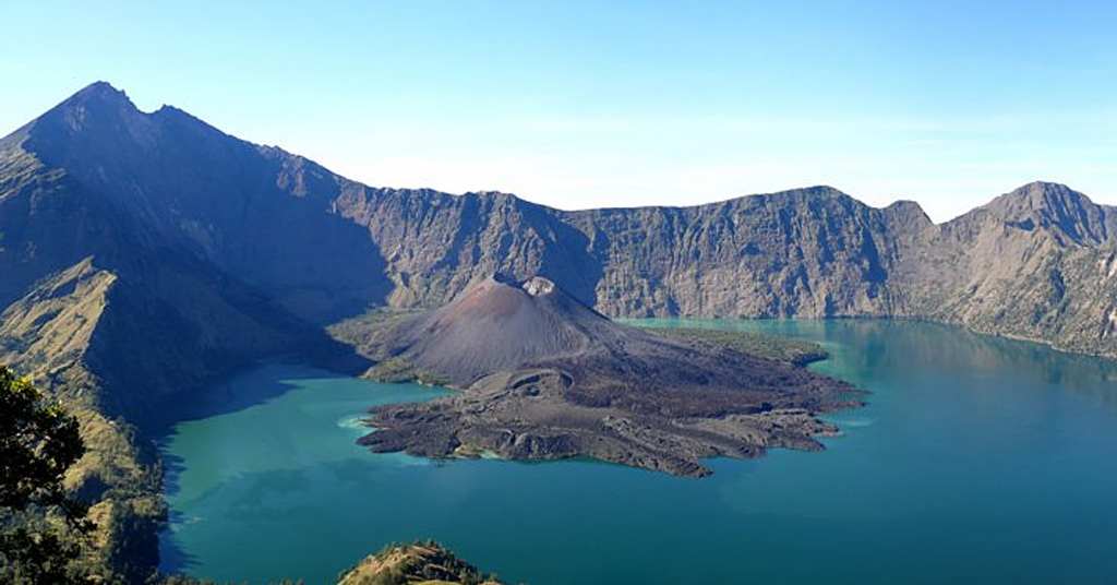 Segara Anak lake fills the caldera of Rinjani volcano on Lombok Island with the cone is Barujari (new mountain). This view shows the interior of the 6 x 8.5 km Segara Anak caldera. Historical eruptions at Rinjani dating back to 1847 have consisted of moderate explosive activity and occasional lava flows from the cone in the center. Photo by Benjamin Barbier, 2007 (Universite Libre de Bruxelles).
