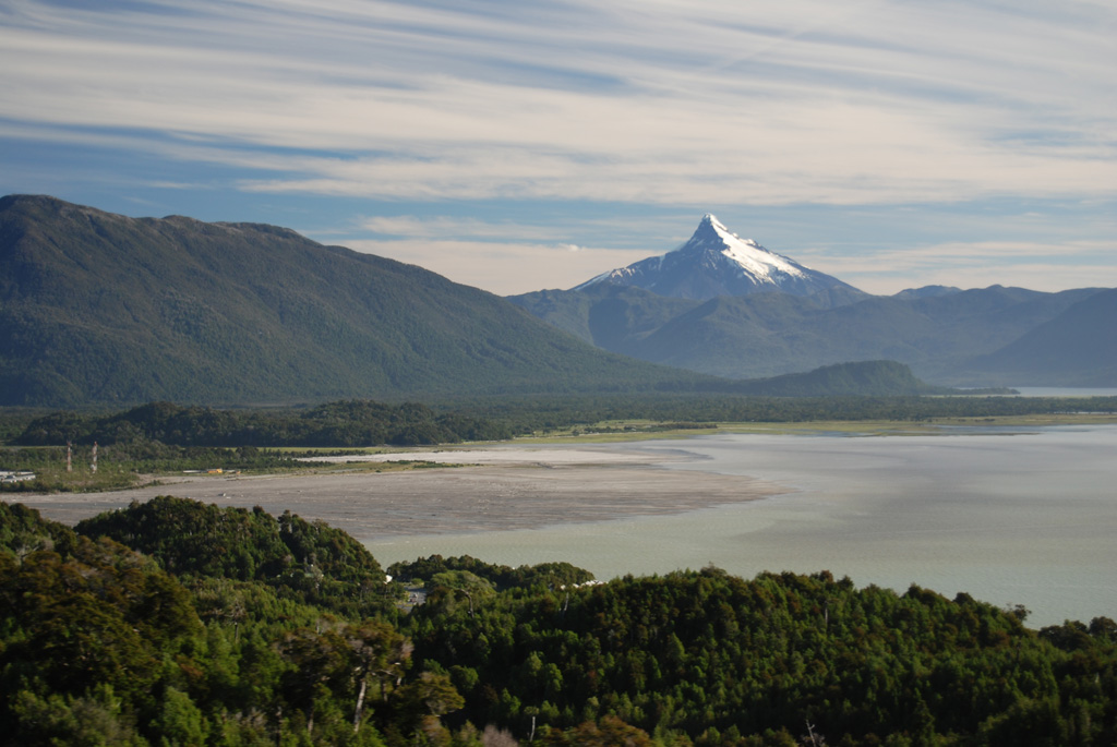 The sharp-topped peak of Corcovado volcano rises above the Gulf of Corcovado as seen from the north from a helicopter near the town of Chaitén.  The glacially eroded volcano is surrounded by Holocene cinder cones. The light-colored delta at the left was formed by lahar deposition during the eruption of Chaitén volcano beginning in 2008. Photo by Jon Major, 2010 (USGS, Cascades Volcano Observatory).