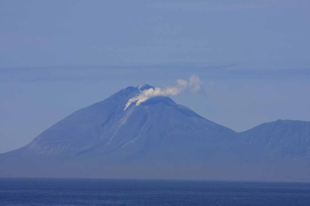 On 30 June 2010, biologists located about ~42 km SW of Ekarma watched as it began to emit large steam-and-gas plumes that were precursory to an eruption. In this photo, the upper plume from the summit dome is weaker than the other two vents but clearly visible. An ash plume erupted from a vent on the upper SW flank later that day and rose to about 3 km altitude. Photo by Andrey Neroda (Pacific Oceanographic Institute FEB RAS), 2010.