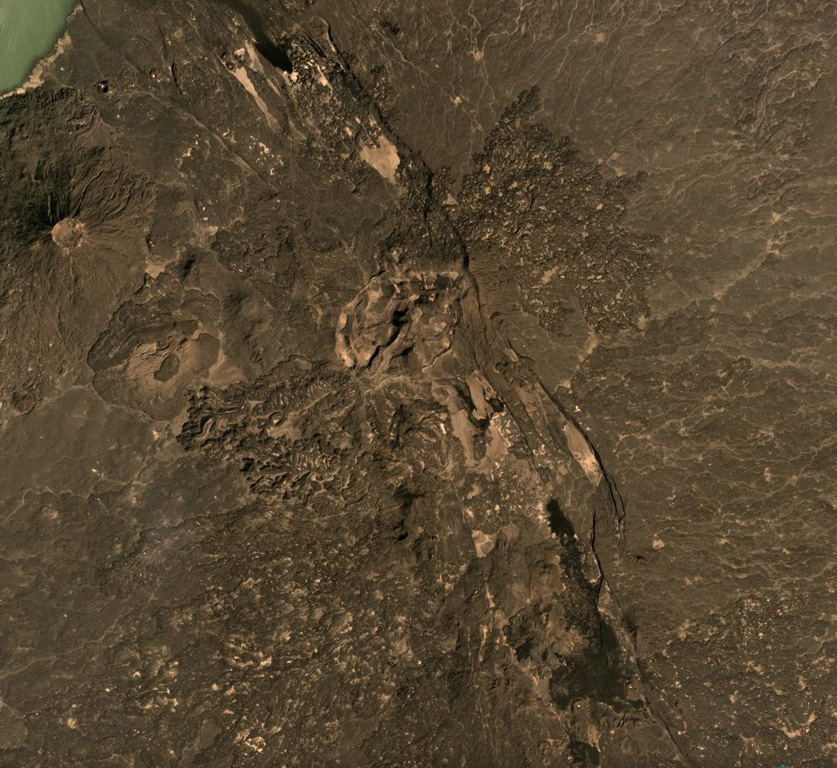 The Tat Ali volcanic complex is located within the NNW-SSE graben visible across this December 2019 Planet Labs satellite image mosaic (N is at the top) with Lake Afrera in the upper left corner. Lava flows have filled the graben, and lavas with flow ridges and levees can be seen near the center of this image. Borawli is the cone to the W, with a roughly 800-m-wide summit crater. Satellite image courtesy of Planet Labs Inc., 2019 (https://www.planet.com/).