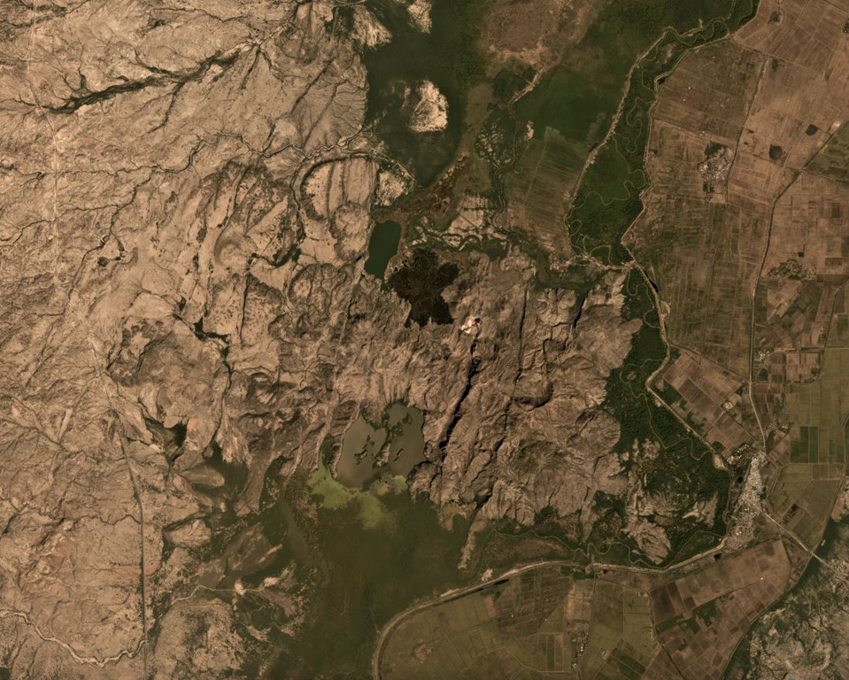 Lava flows form the southern flank of the Dofan volcanic massif, NW of a bend in the Hauash River, in the center of this December 2019 Planet Labs satellite image monthly mosaic (N is at the top, this image is approximately 20 km across). A darker lava flow above the center of this image erupted from a younger northern vent on the flank. Along with Fantale volcano to the SW, this area is one of the geothermal fields of Ethiopia. Satellite image courtesy of Planet Labs Inc., 2019 (https://www.planet.com/).