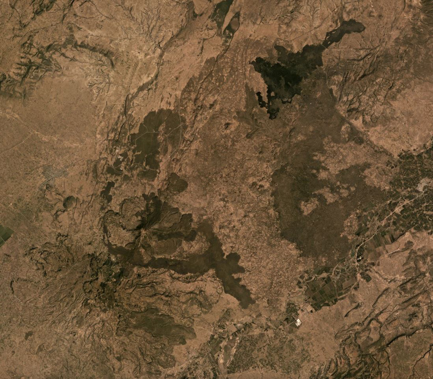 The Gudda and Bericha edifices comprise the Boset volcanic complex, one of the largest volcanoes within the northern Main Ethiopia Rift at 17 x 20 km in extent. The main edifices are in the lower left quarter of this November 2019 Planet Labs satellite image monthly mosaic with darker, younger lava flows on the flanks and to the NE at Kone (N is at the top; this image is approximately 39 km across). The Boset-Gudda) cone forms the SW potion, and the Boset-Bericha cone is NE. Satellite image courtesy of Planet Labs Inc., 2019 (https://www.planet.com/).